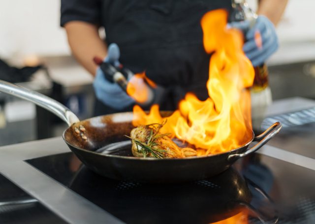 chef-with-gloves-flambeing-dish-scaled